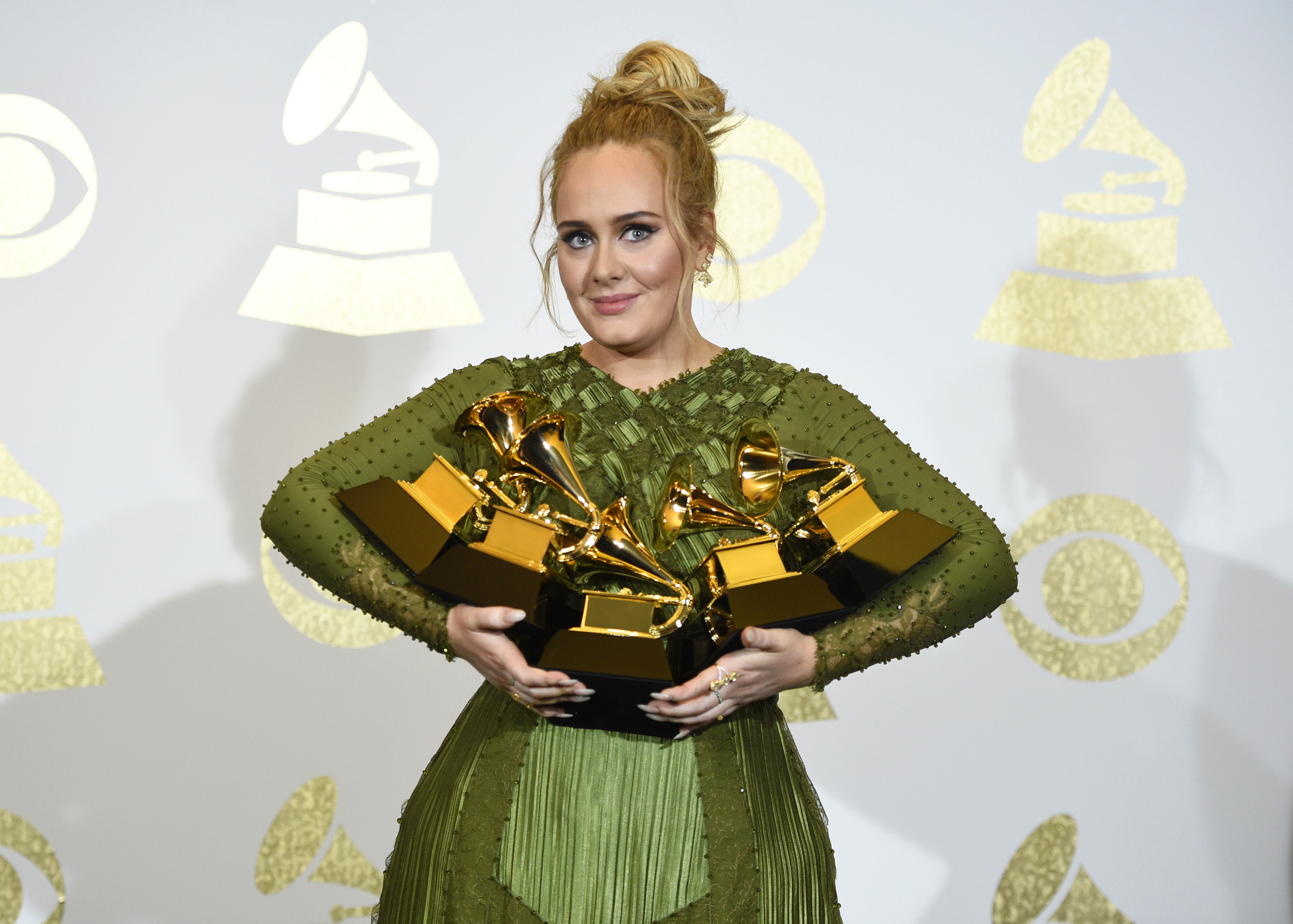 Adele poses in the press room with the awards for album of the year for '25', song of the year for 'Hello', record of the year for 'Hello', best pop solo performance for 'Hello', and best pop vocal album for '25' at the 59th annual Grammy Awards at the Staples Center on in Los Angeles- AP